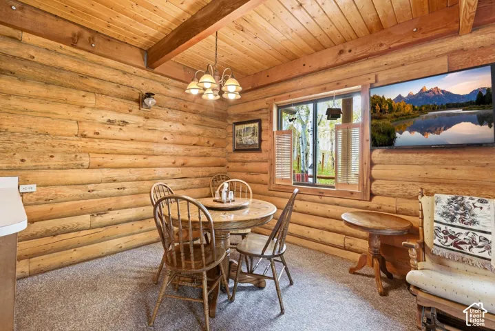 Interior room featuring log walls, wood-finish ceiling, and exposed ceiling beams