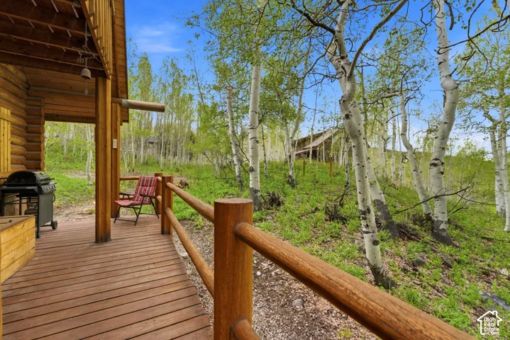 Expansive log-style exterior featuring a covered porch with wood decking