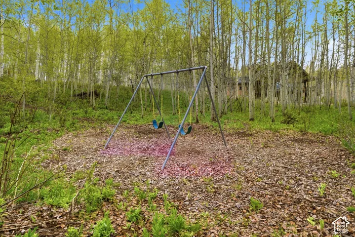 Wooded property featuring a metal swing set