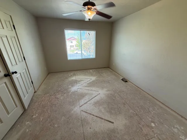 Unit B - Room featuring a window with blinds, ceiling fan with integrated lighting, and neutral wall tones