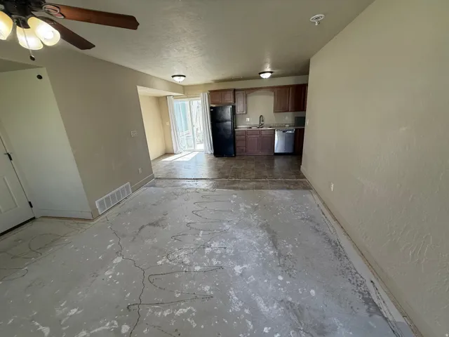 Unit B - Kitchen area with wood-finish cabinetry, stainless steel sink, and dishwasher