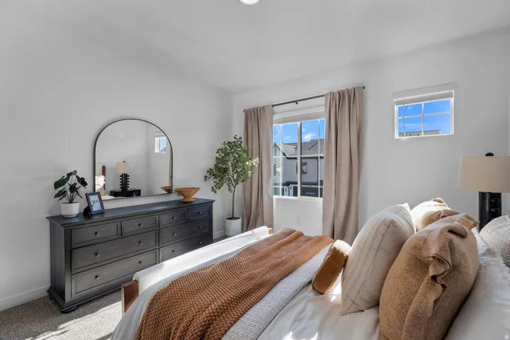 Carpeted bedroom featuring white walls and multiple windows for natural light