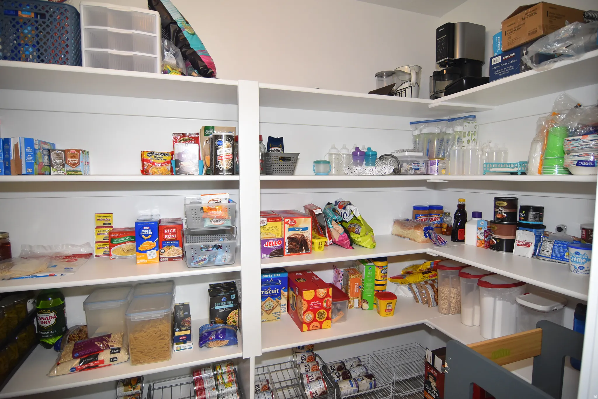 Spacious pantry featuring white shelving, multi-level storage, and built-in wire racks