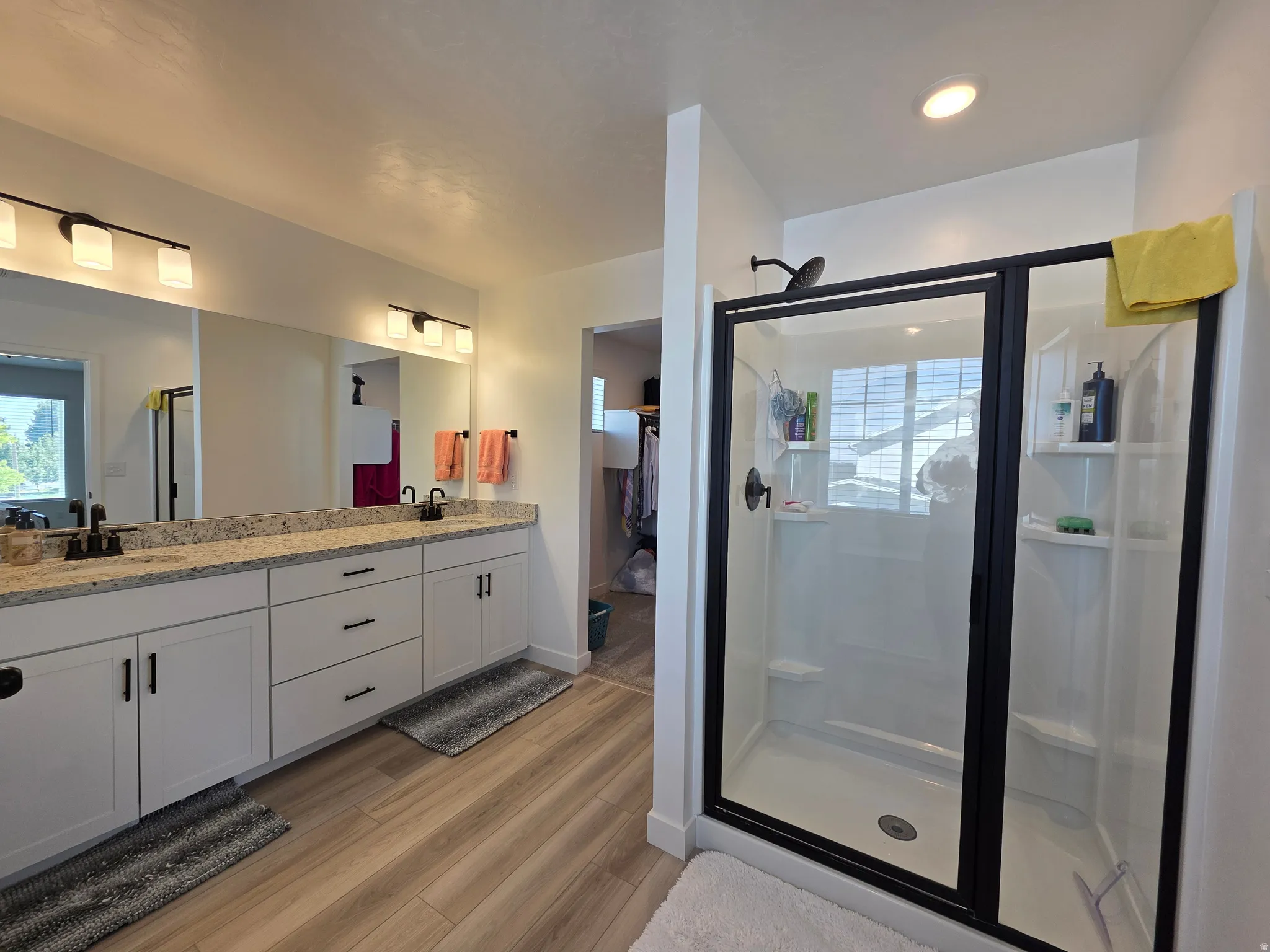 Dual vanity with granite-finish countertop, undermount sinks, and matte black fixtures