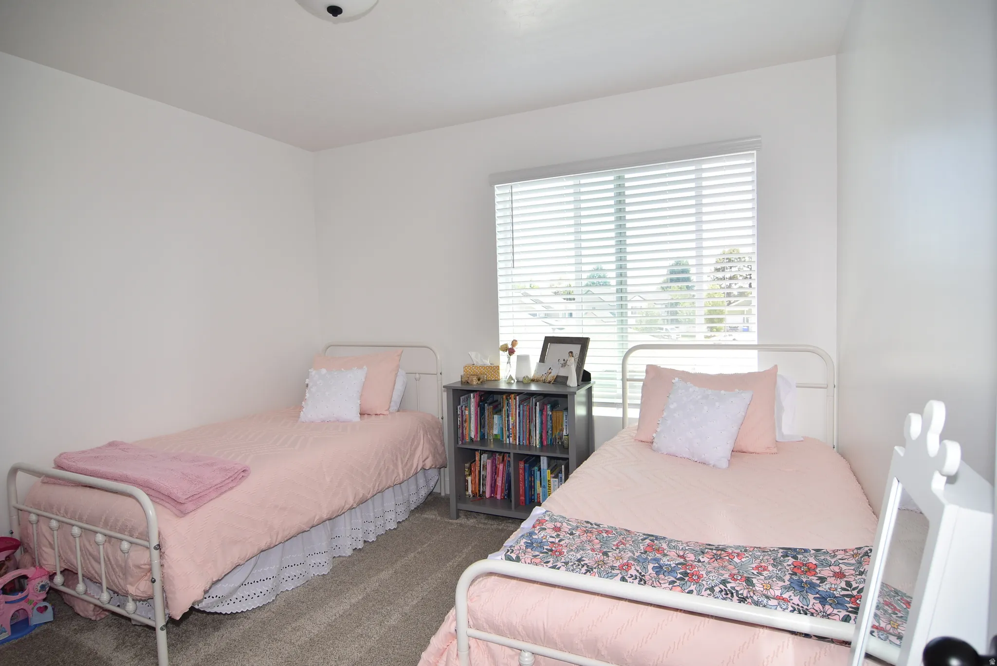 Bedroom #3 featuring neutral carpeting, white walls, a single window with blinds, and a flush-mount ceiling light fixture