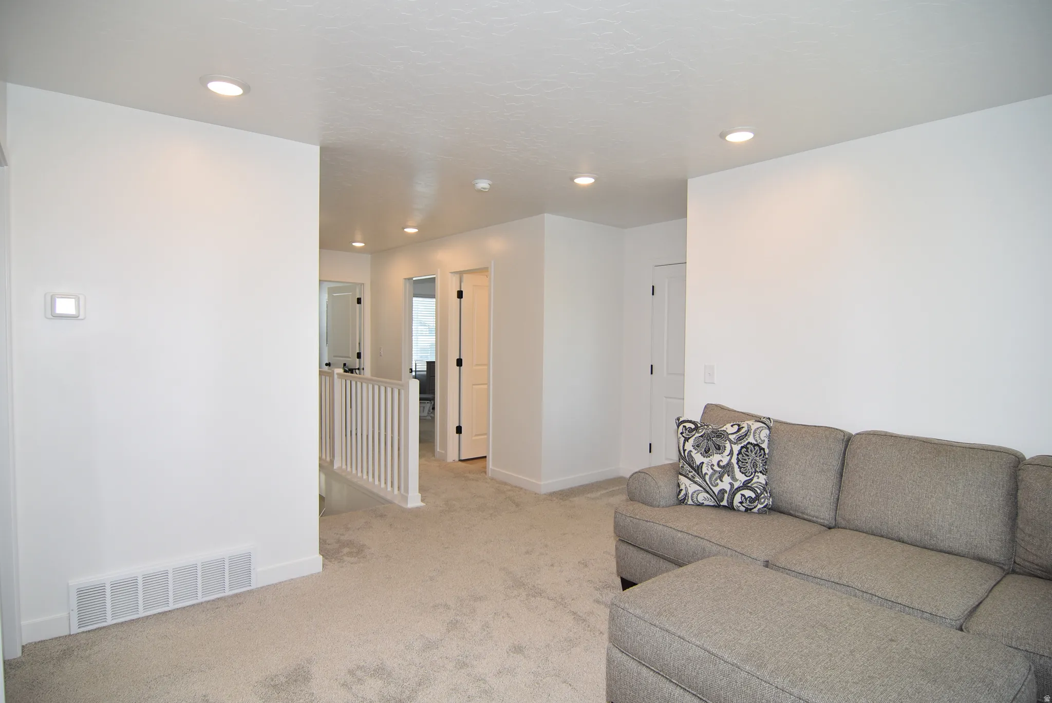 Carpeted interior with recessed lighting, white walls, and white baseboards