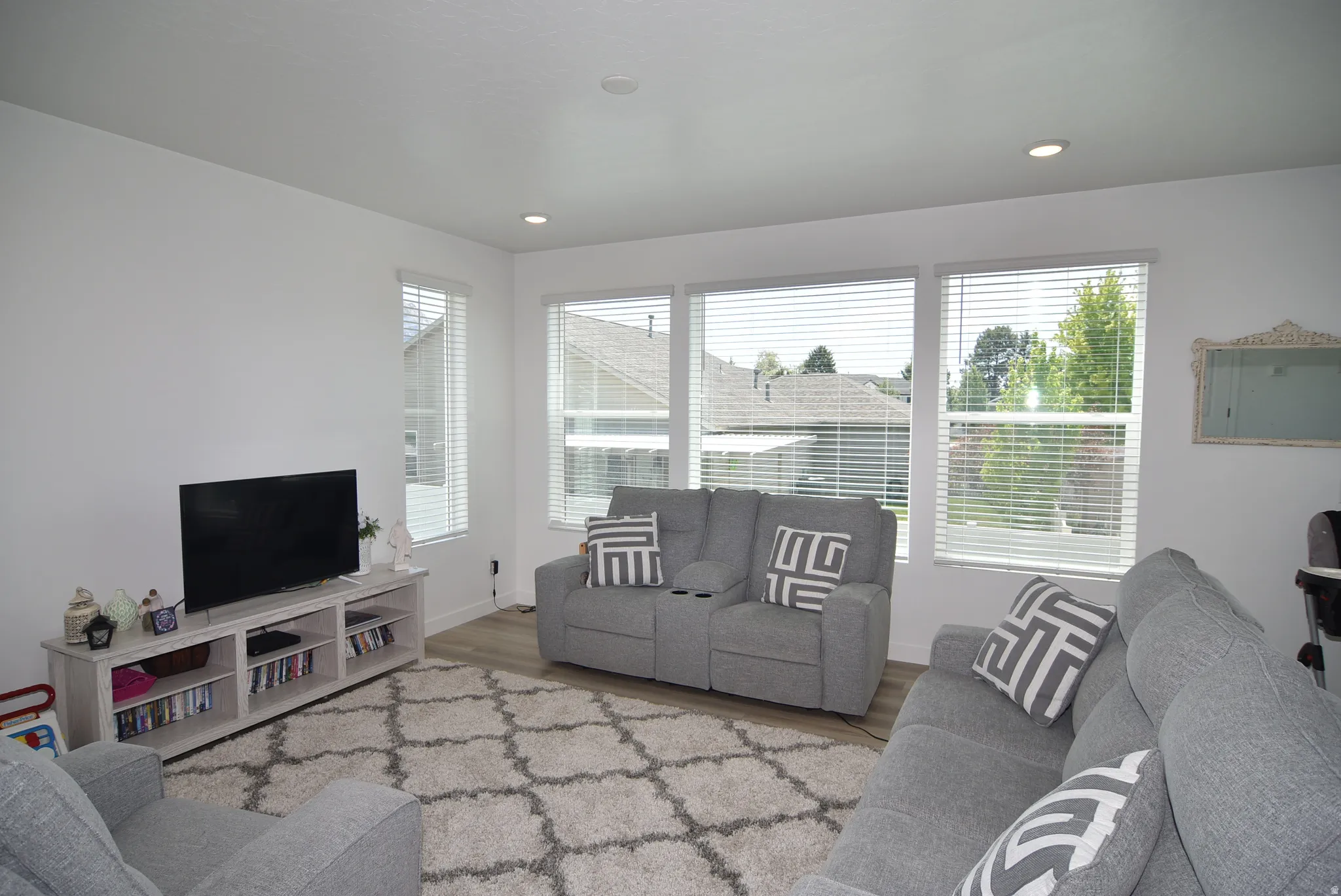 Bright living area featuring wood-finish flooring and recessed lighting