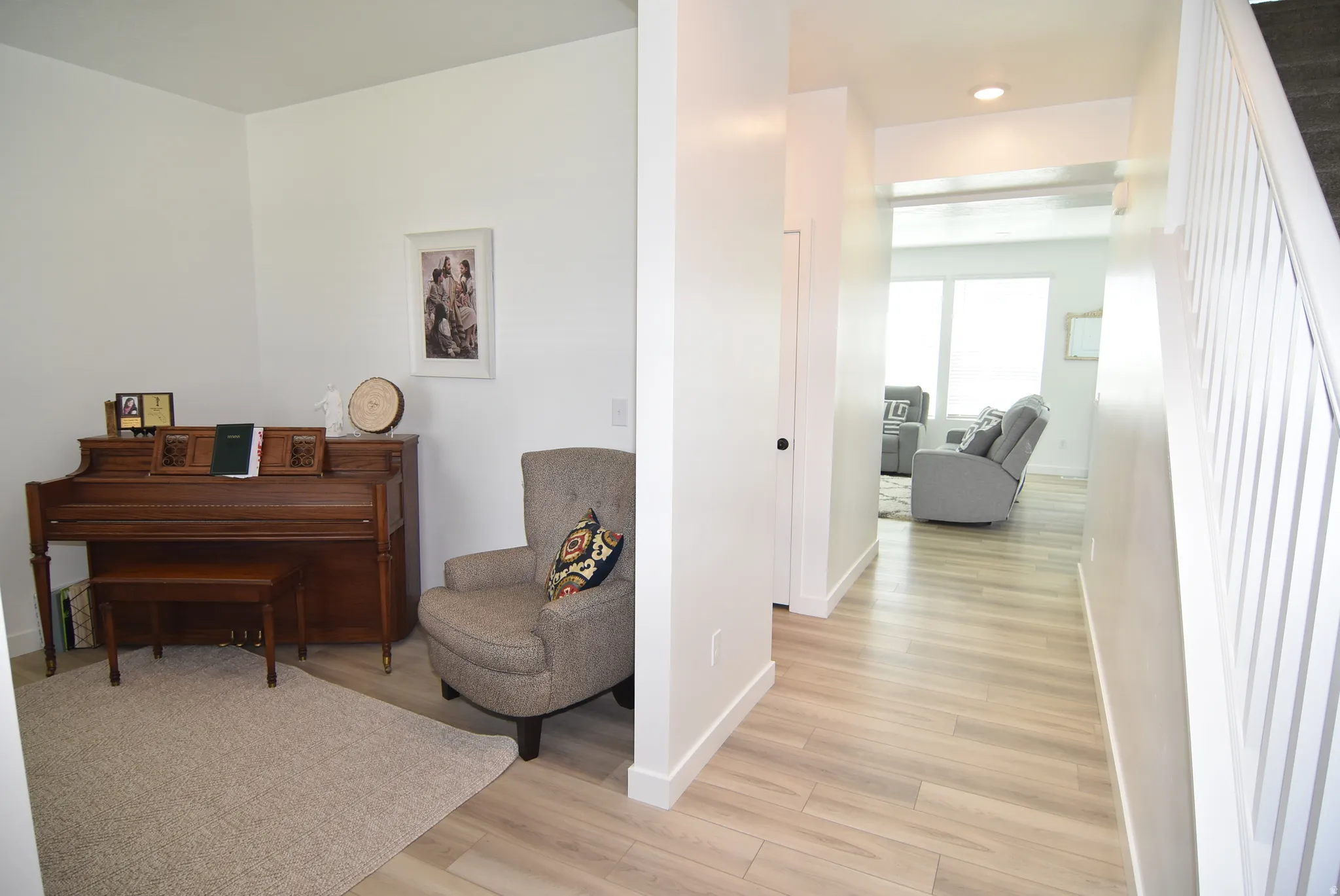 Hallway with light wood-finish flooring extending into living areas