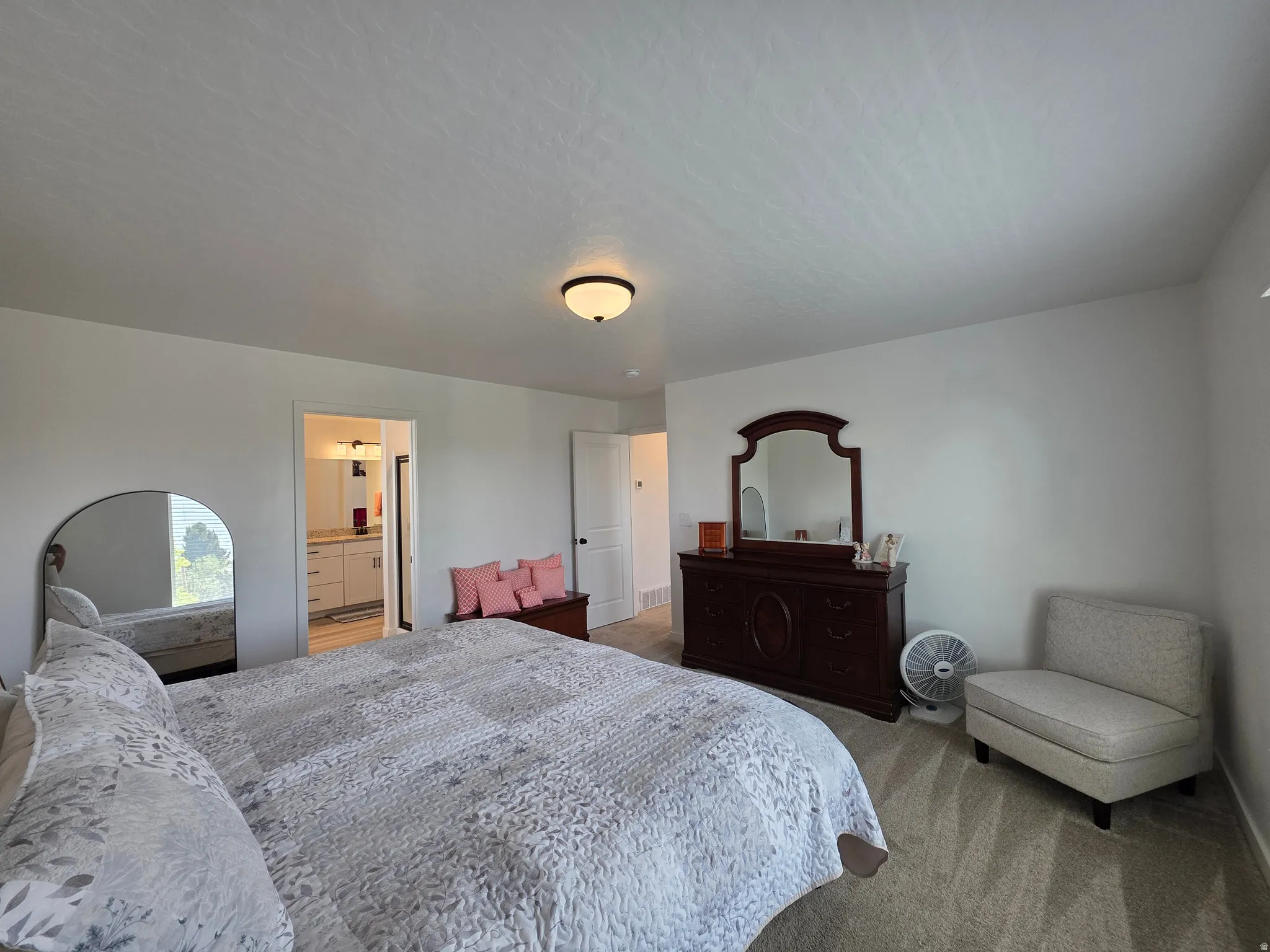 Spacious room featuring neutral carpeting, white walls, and an overhead flush-mount light fixture