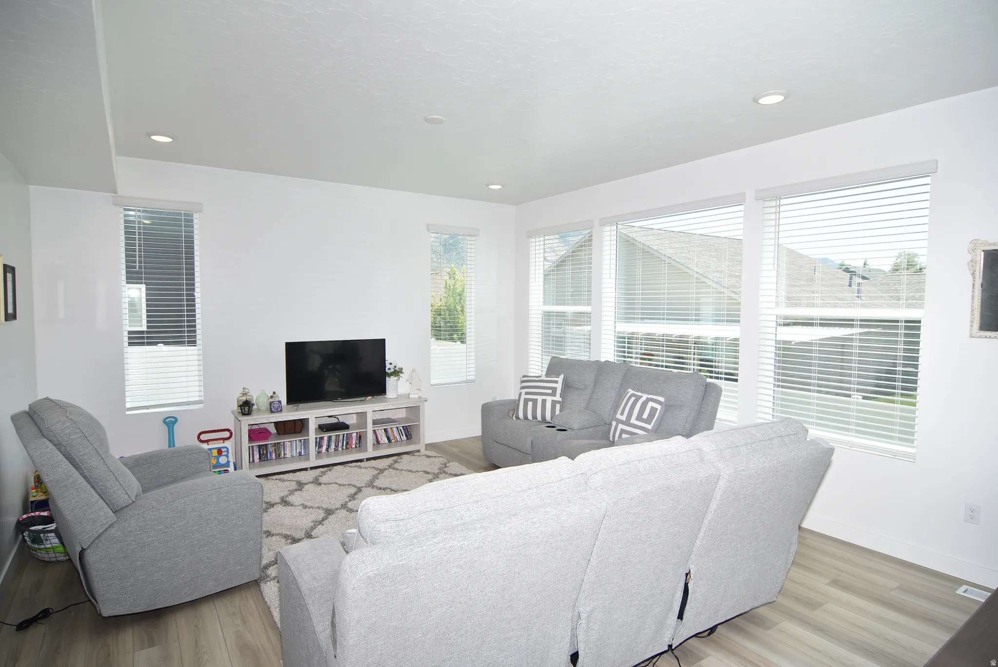 Bright living area featuring wood-finish flooring and recessed ceiling lights