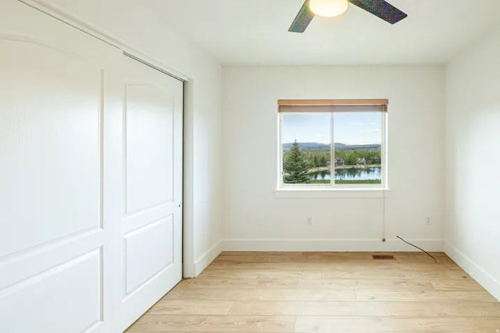 Bright interior space featuring wood-finish flooring, white walls, and a ceiling fan