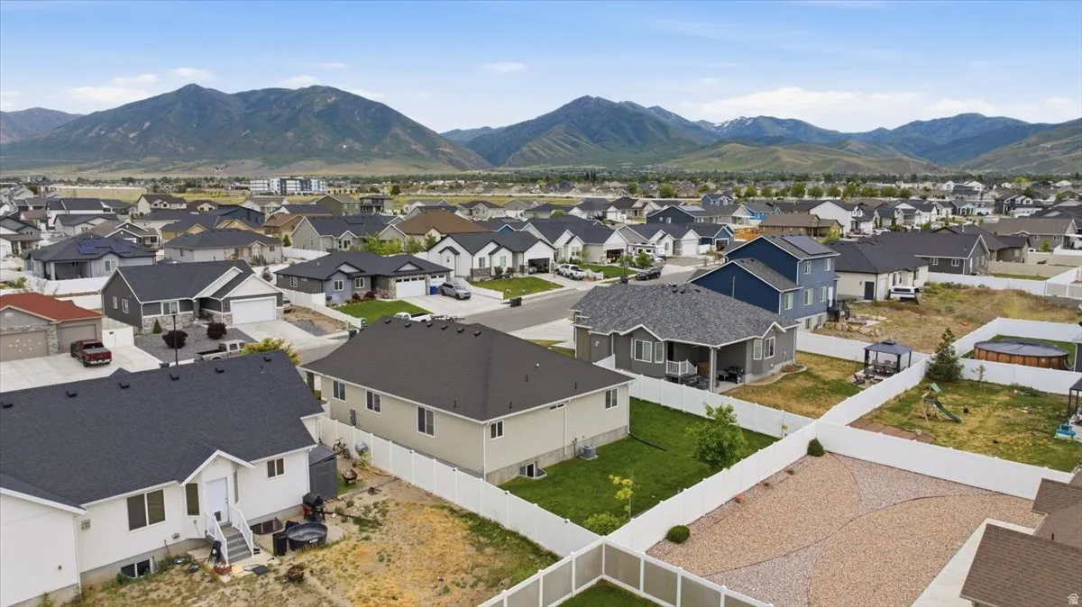 Aerial perspective showcasing a residential area with varied housing styles and mountain scenery