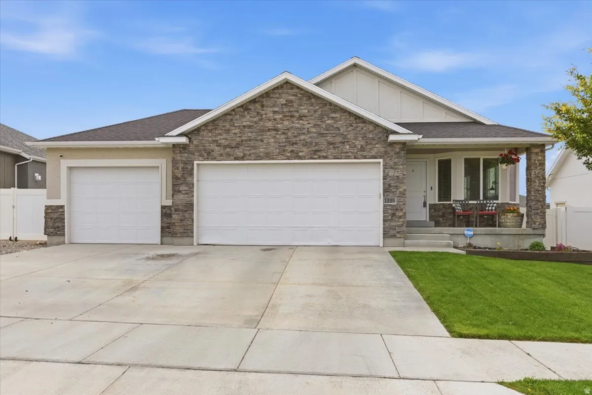 Crafted stone and stucco exterior with a three-car garage