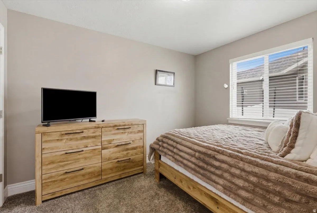 Neutral-toned room featuring a large window with horizontal blinds, providing ample natural light