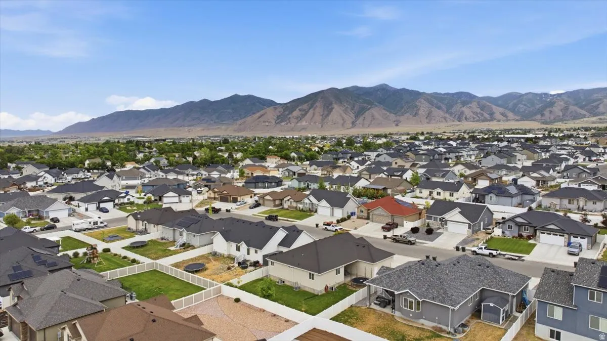Residential neighborhood with varied architectural styles and mature landscaping, situated against a backdrop of distant mountains