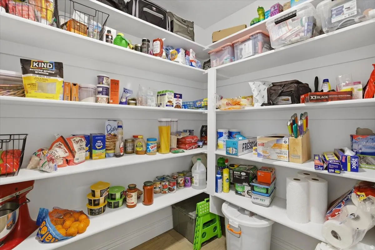 Custom-built oversized pantry featuring extensive shelving, white finishes, and ample storage capacity