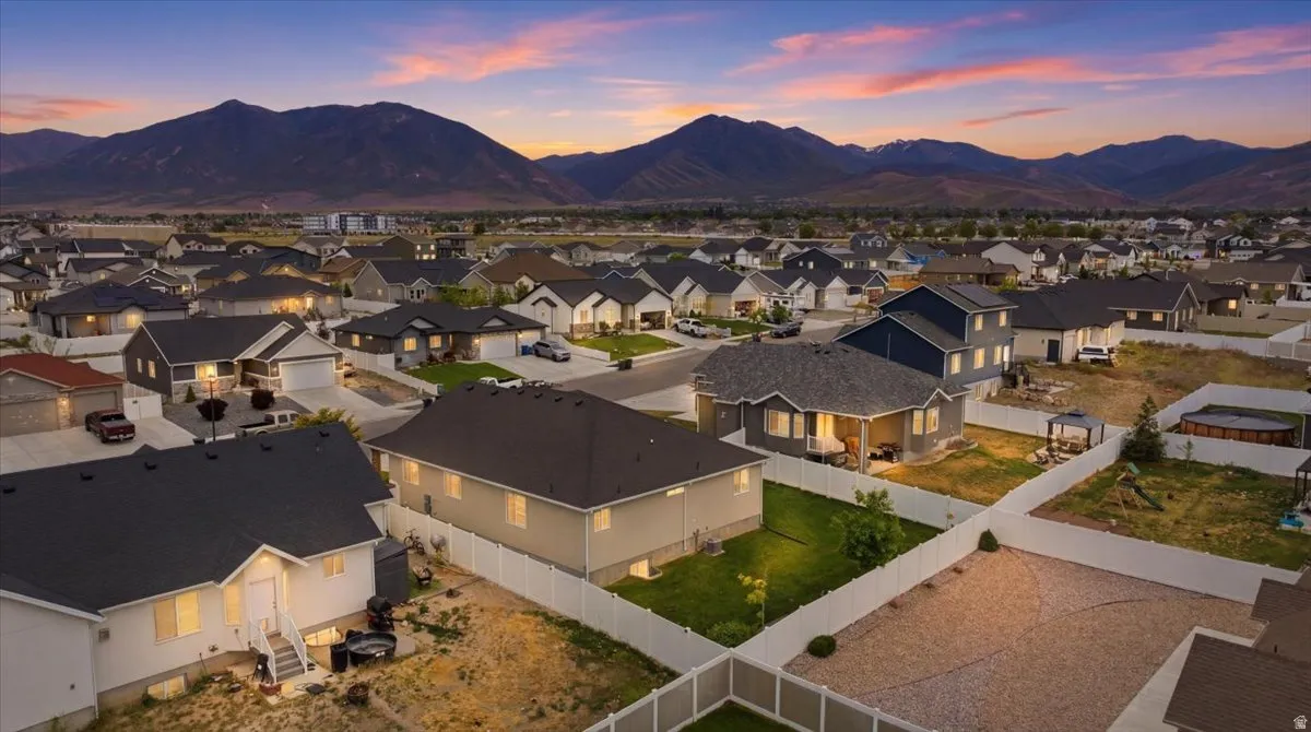 Aerial perspective of a residential neighborhood featuring diverse architectural styles and a backdrop of mountains