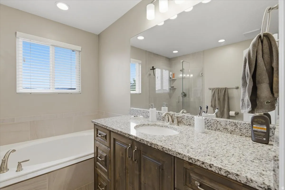 Vanity with a granite countertop and integrated sink