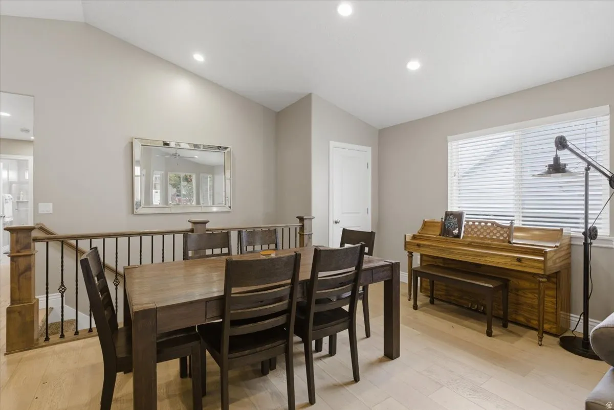 Dining area featuring vaulted ceilings, recessed lighting, and light wood-finish flooring