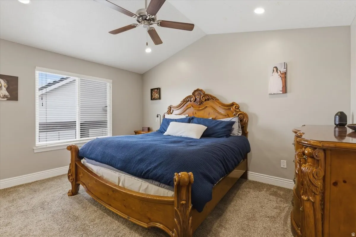 Bedroom with vaulted ceiling and recessed lighting, and a ceiling fan