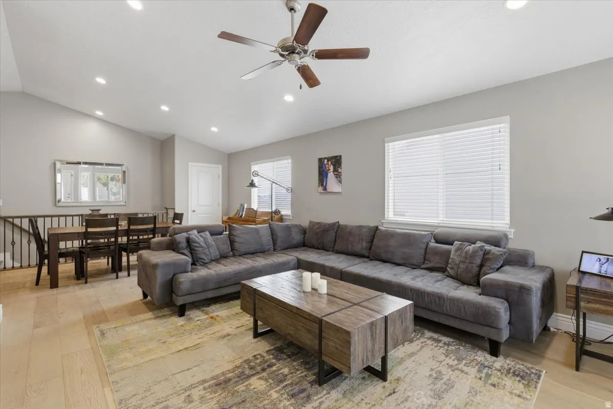 Open-concept living area featuring vaulted ceilings, recessed lighting, and light wood-finish flooring