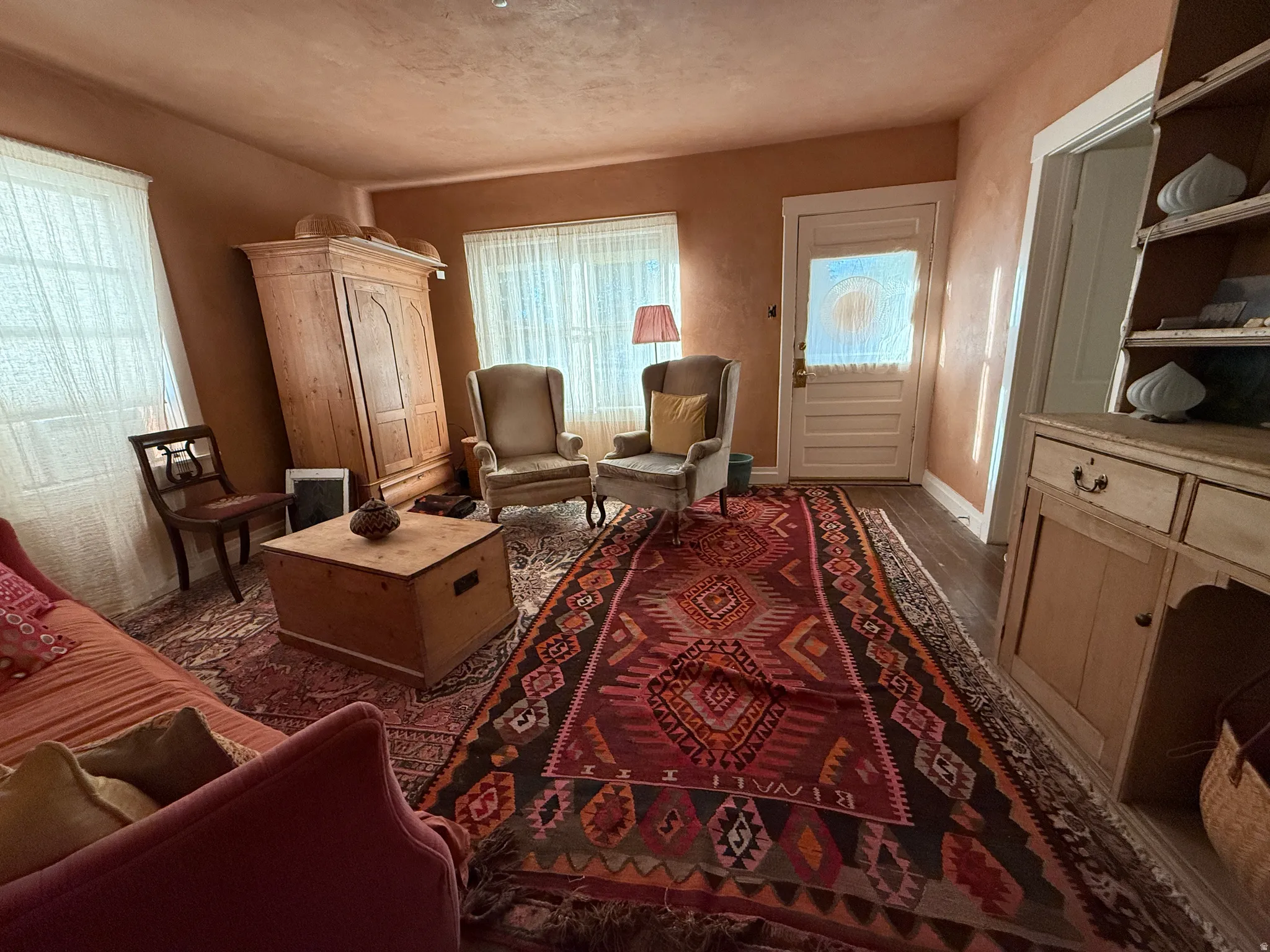 Hardwood-style flooring extends throughout this room, complemented by a light-colored entry door with frosted glass