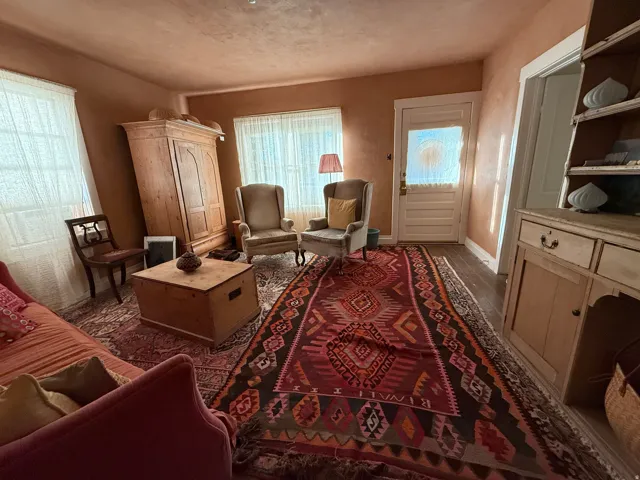 Hardwood-style flooring extends throughout this room, complemented by a light-colored entry door with frosted glass