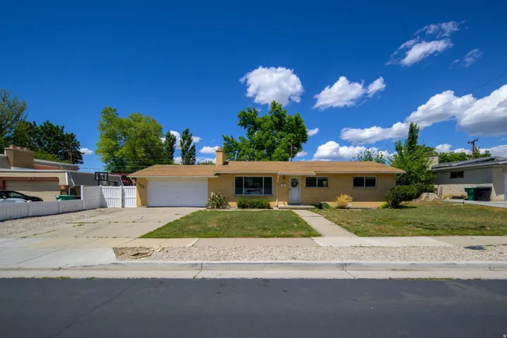 Ranch-style residence featuring a brick facade, attached two-car garage, and a front walk leading to the entryway