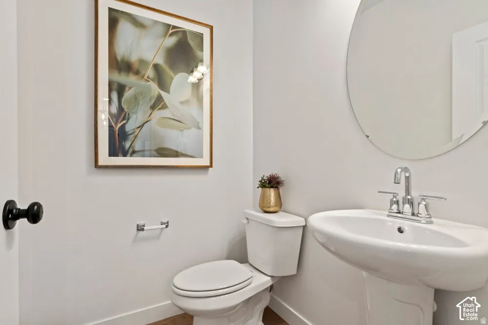 Pedestal sink with chrome faucet, complemented by a contemporary round mirror