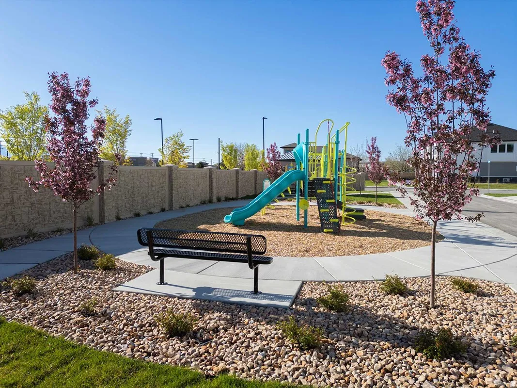 Community playground featuring a blue and yellow play structure on a wood chip base