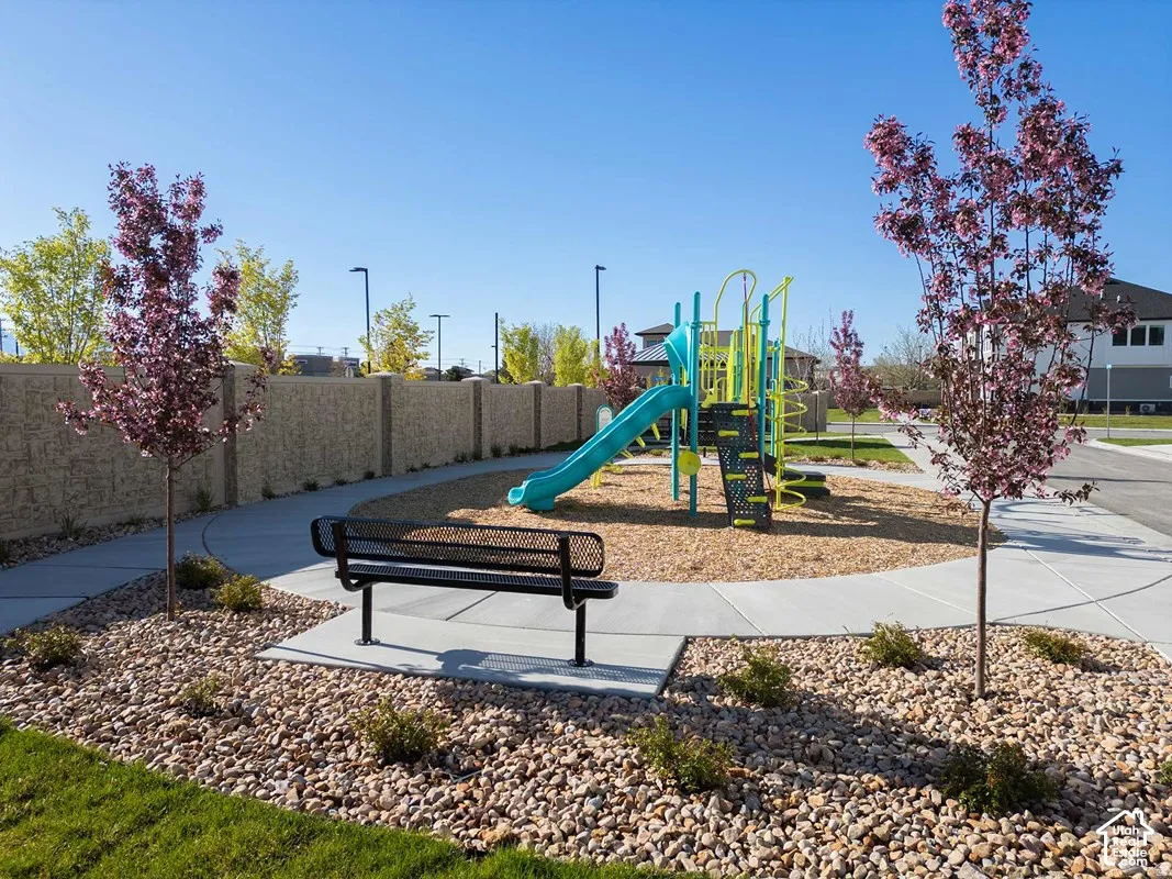 Community playground featuring a blue and yellow play structure on a wood chip base