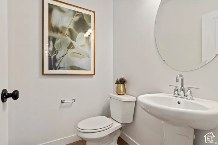 Pedestal sink with chrome faucet, complemented by a contemporary round mirror