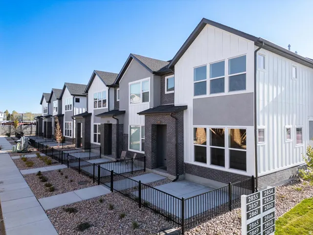 Contemporary townhome exterior featuring vertical white siding and gray stucco accents