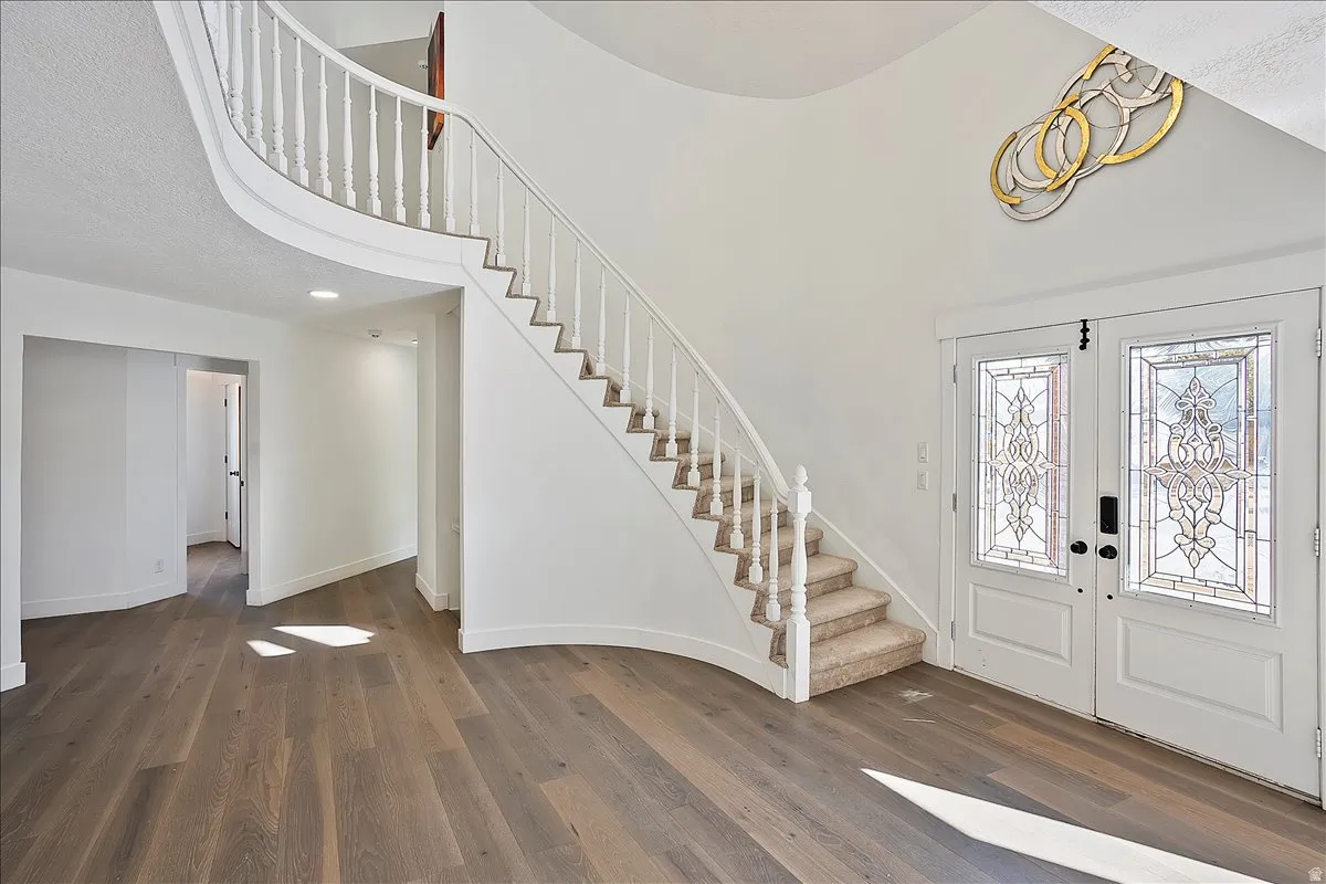 Grand entry featuring a curved staircase with white balusters and carpeted treads