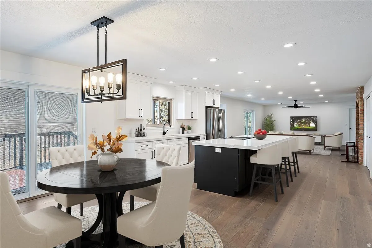 Open-concept living space featuring wood-finish flooring, recessed lighting, and a contemporary chandelier