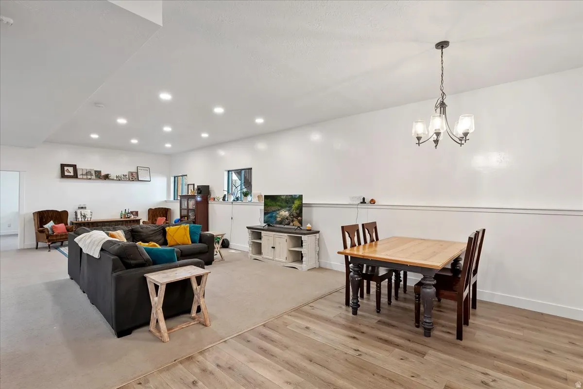 Spacious open-concept living area featuring wood-finish flooring, recessed lighting, and a neutral color palette