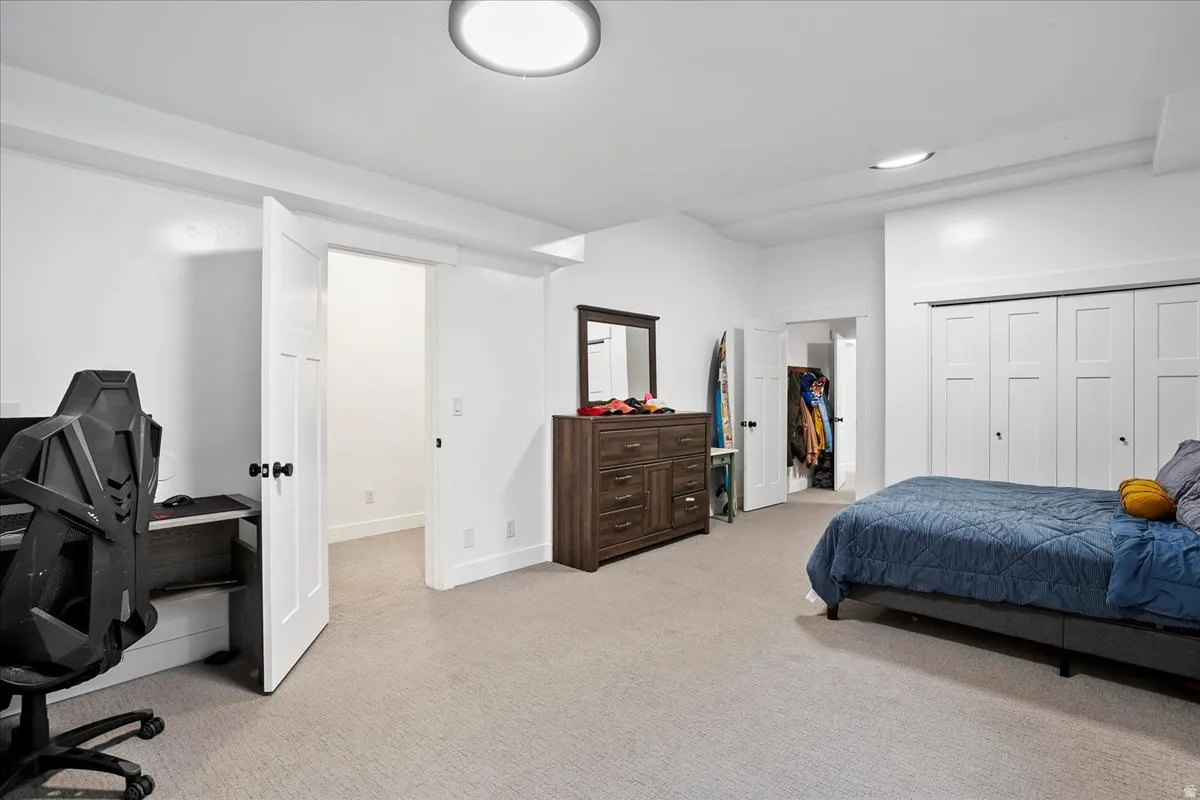 Spacious room featuring light gray carpet, white walls, and bright overhead lighting