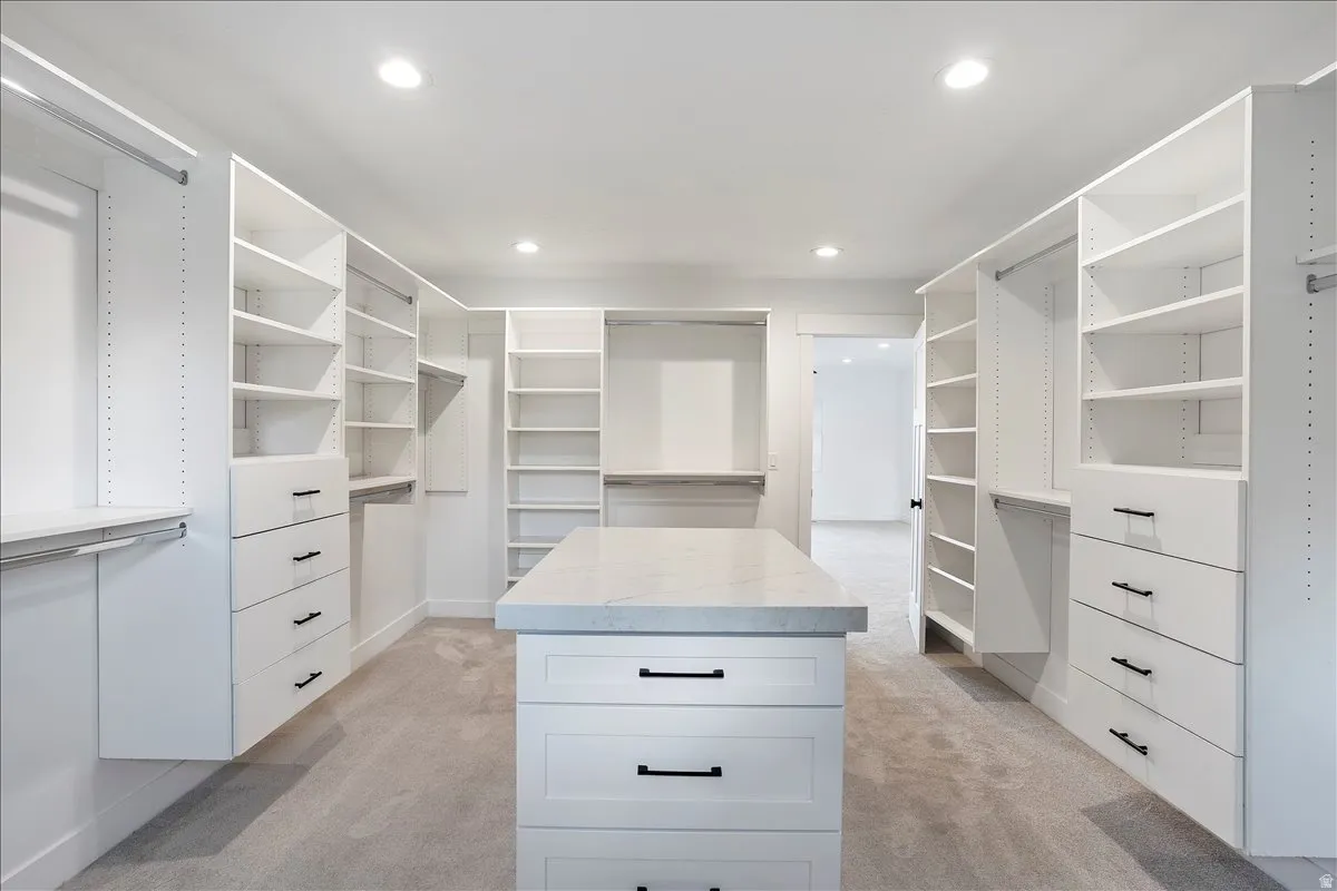 Custom-designed walk-in closet featuring extensive built-in shelving, multiple hanging rods, and integrated drawer storage