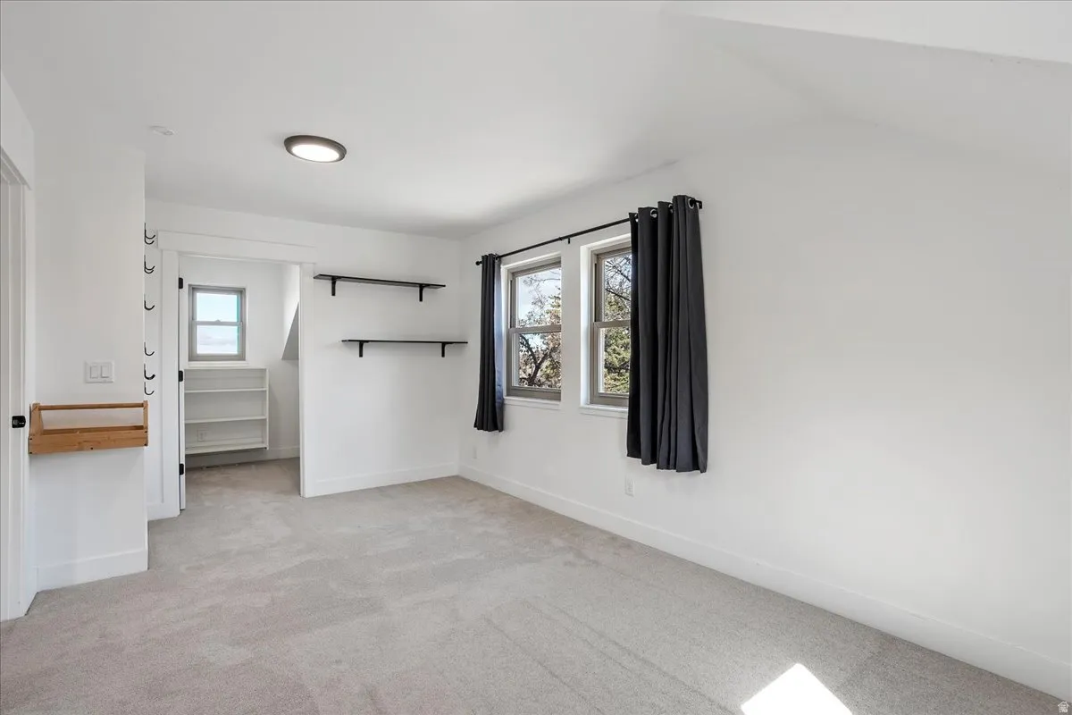Carpeted room with a flush-mount ceiling light and two windows