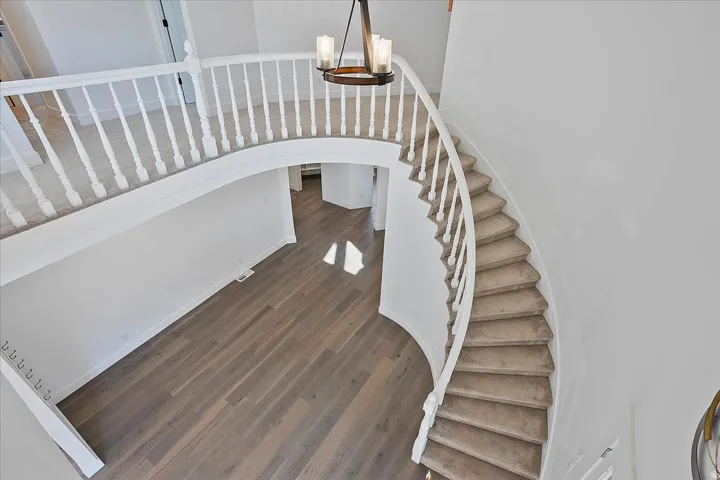 Grand curved staircase with carpeted treads and white balusters
