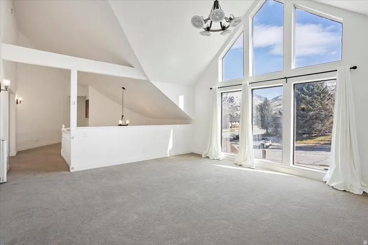 Vaulted ceilings with a statement chandelier illuminate this expansive room
