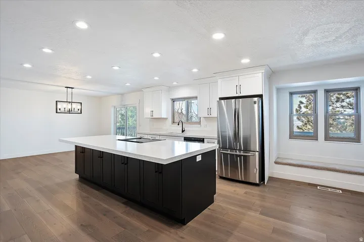 Open-concept kitchen featuring a large island with dark cabinetry and a light-toned countertop