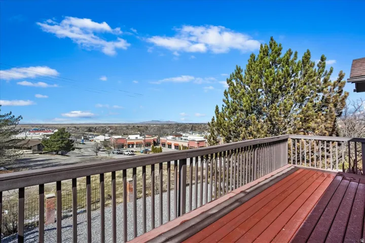 Expansive outdoor deck featuring dark-stained wood-finish flooring and a matching perimeter railing
