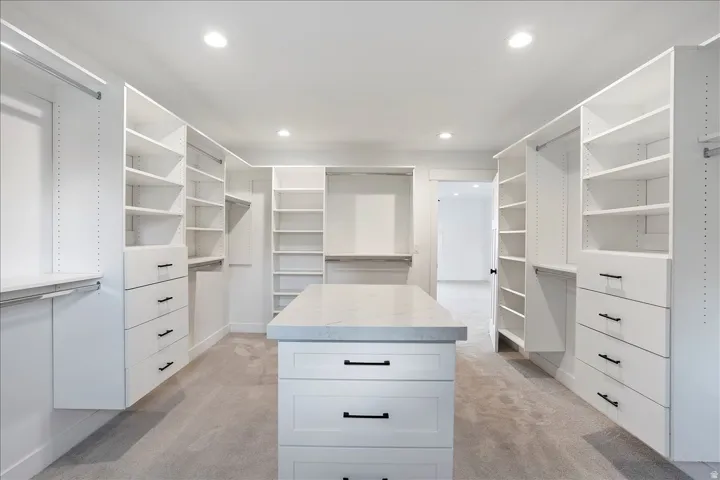 Custom-designed walk-in closet featuring extensive built-in shelving, multiple hanging rods, and integrated drawer storage