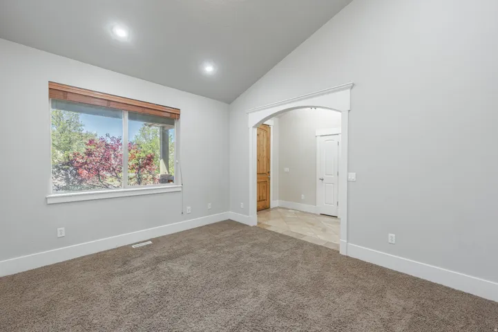 Carpeted room featuring a vaulted ceiling and recessed lighting