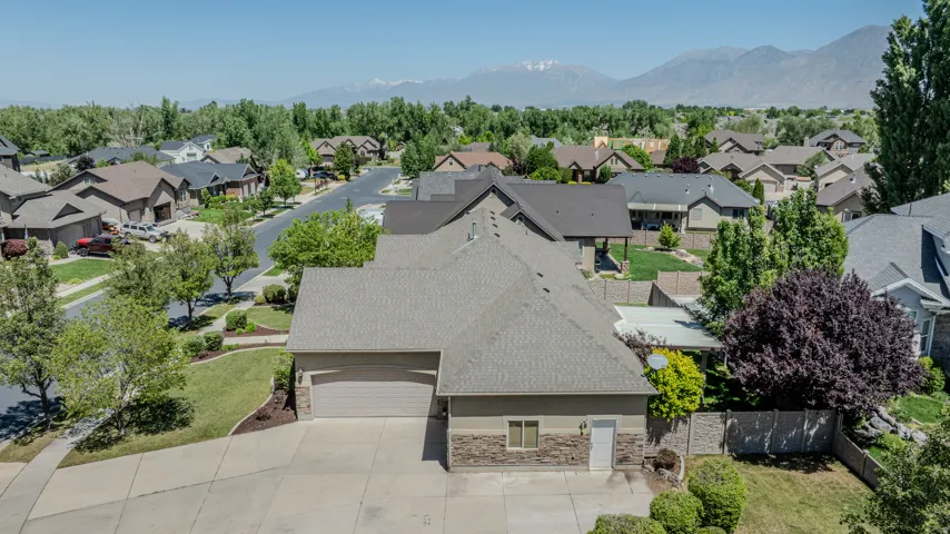 Contemporary single-family residence featuring a two-car garage, stone accent siding, and a concrete driveway