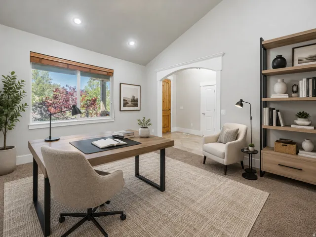 Vaulted ceiling room featuring a large window, recessed lighting, an arched doorway with wood trim, and a built-in shelving unit with drawers