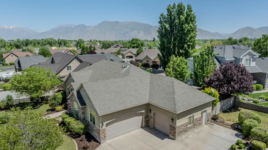 Stucco and stone facade home featuring an attached two-car garage and a paved driveway