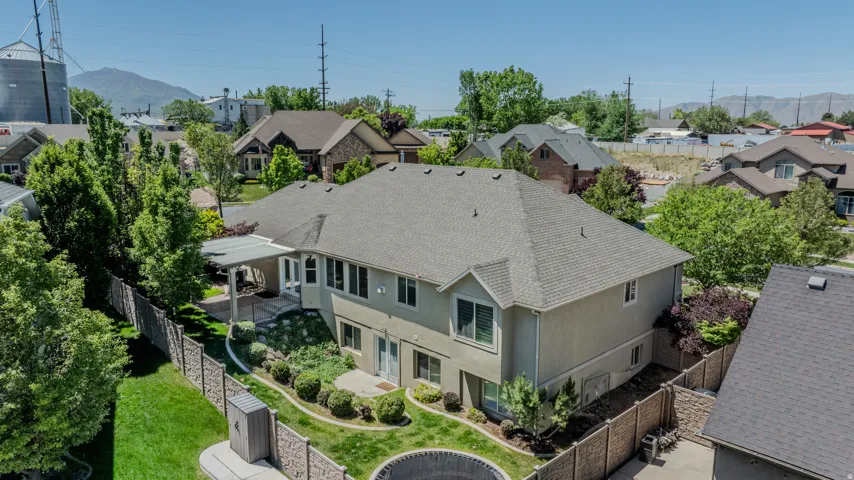 Rear exterior featuring a covered patio, lower-level patio, and terraced landscaping