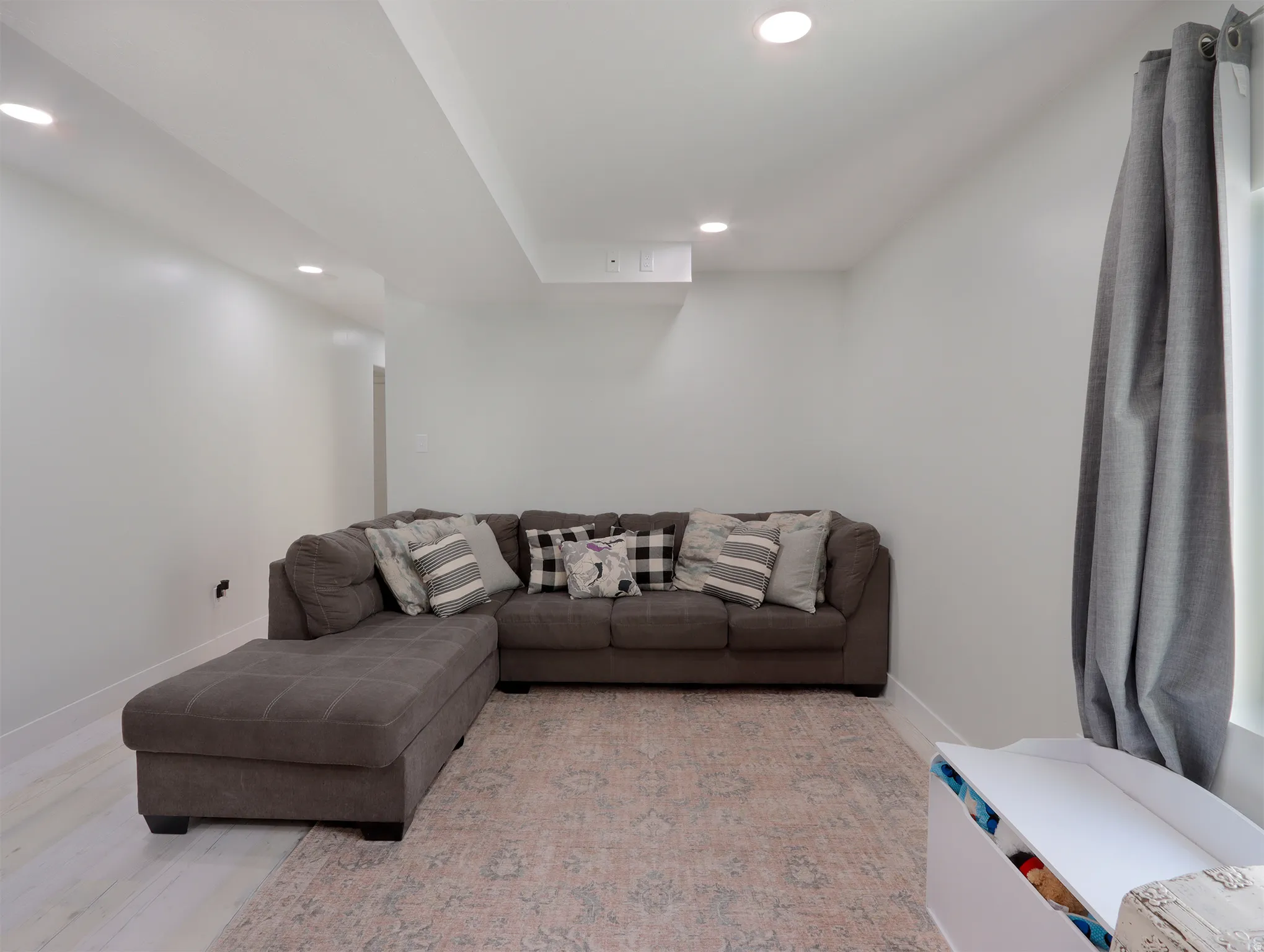 Spacious interior area featuring recessed lighting, a window with drapery, and light-toned wood-finish flooring